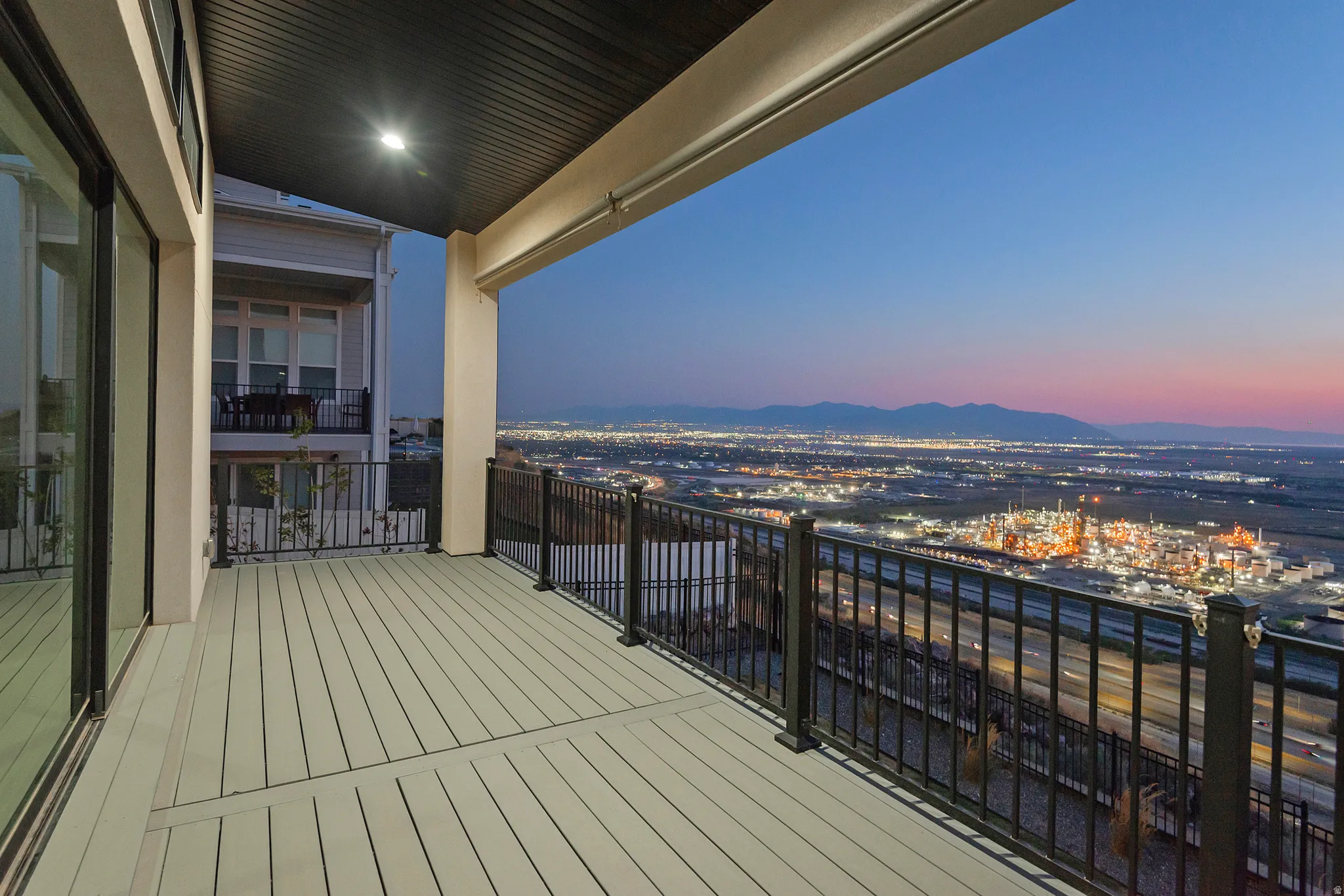 Covered balcony featuring composite decking and black metal railings