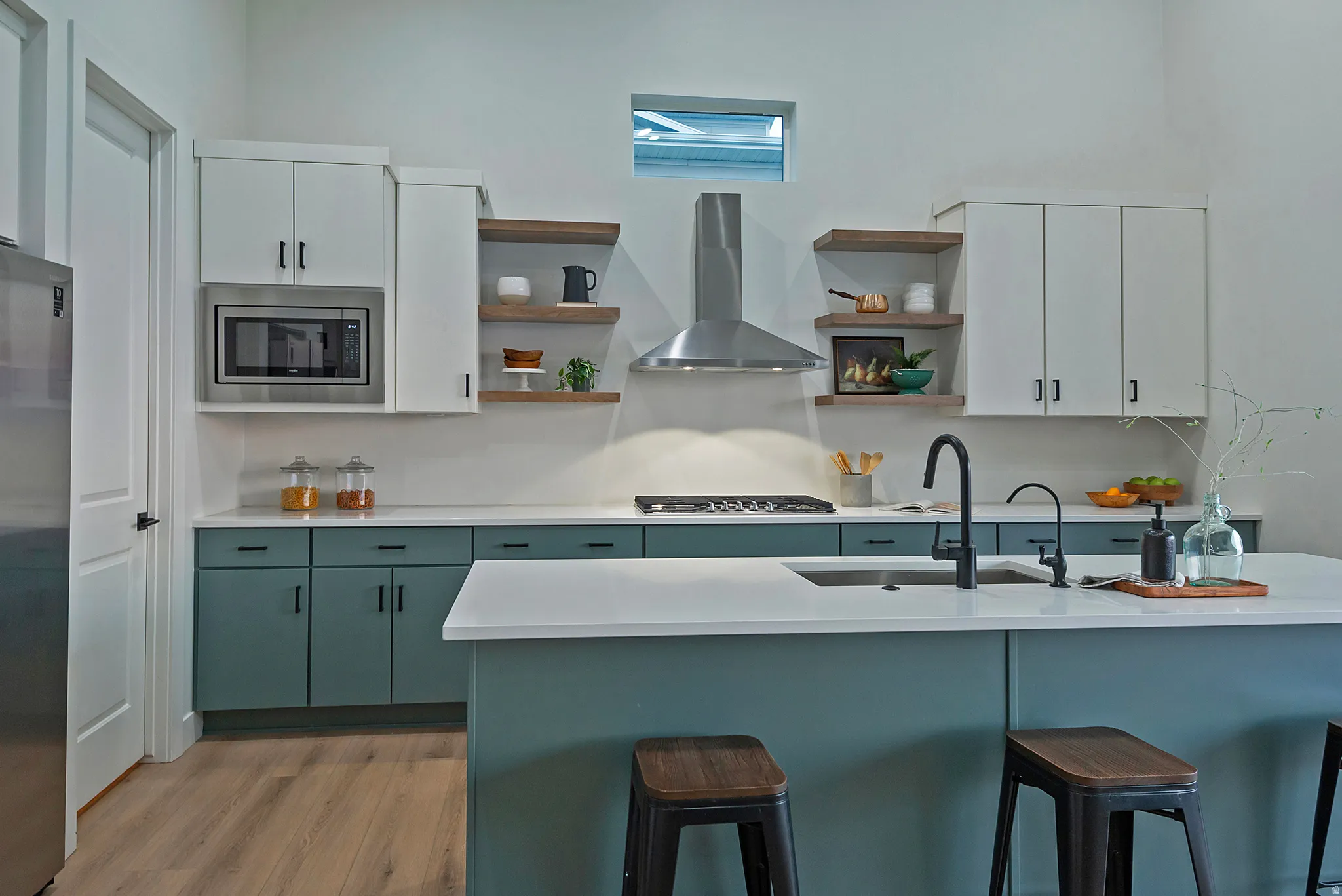 Modern kitchen featuring a central island with an integrated sink and black faucet