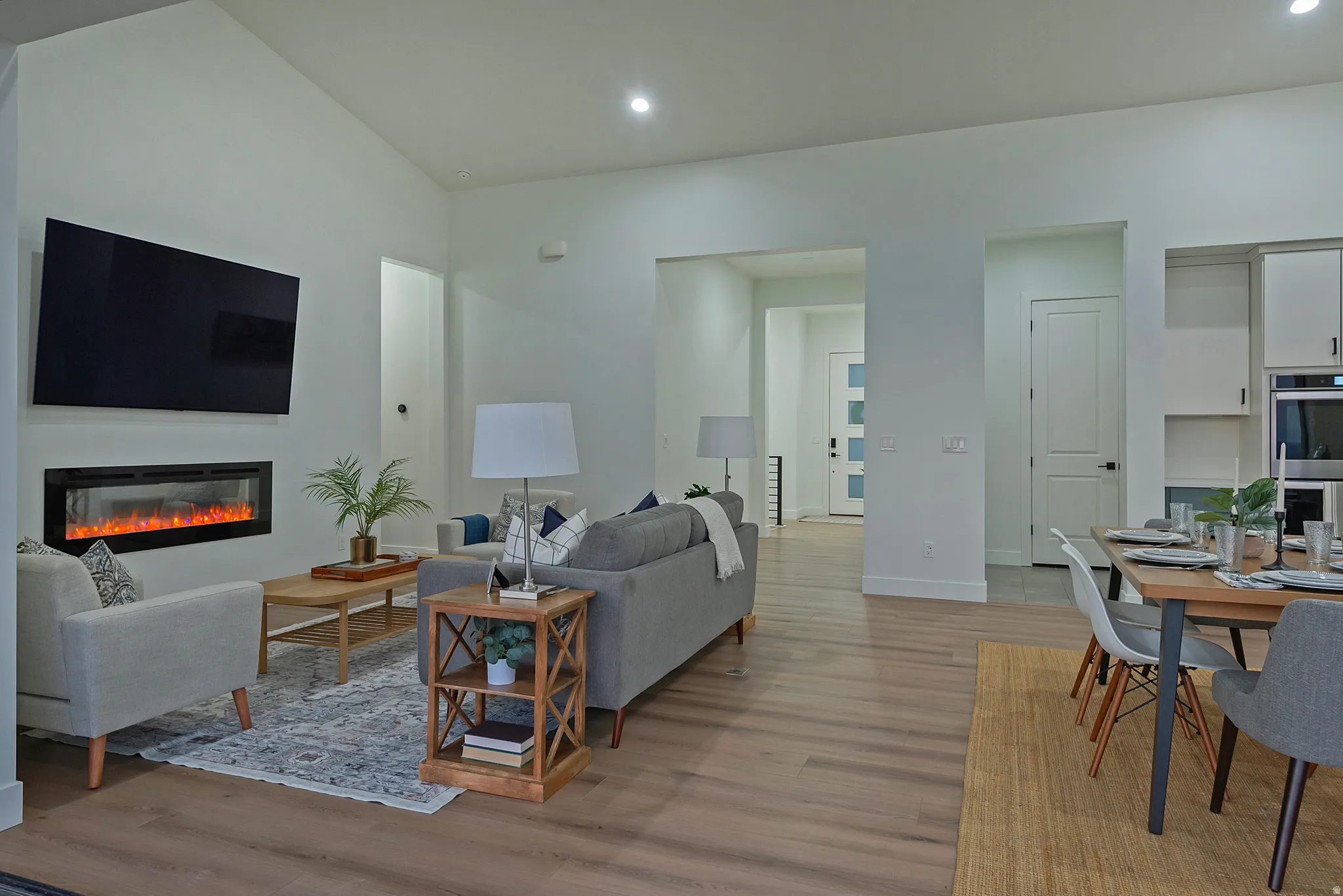 Open-concept living space featuring wood-finish flooring, recessed lighting, and vaulted ceilings