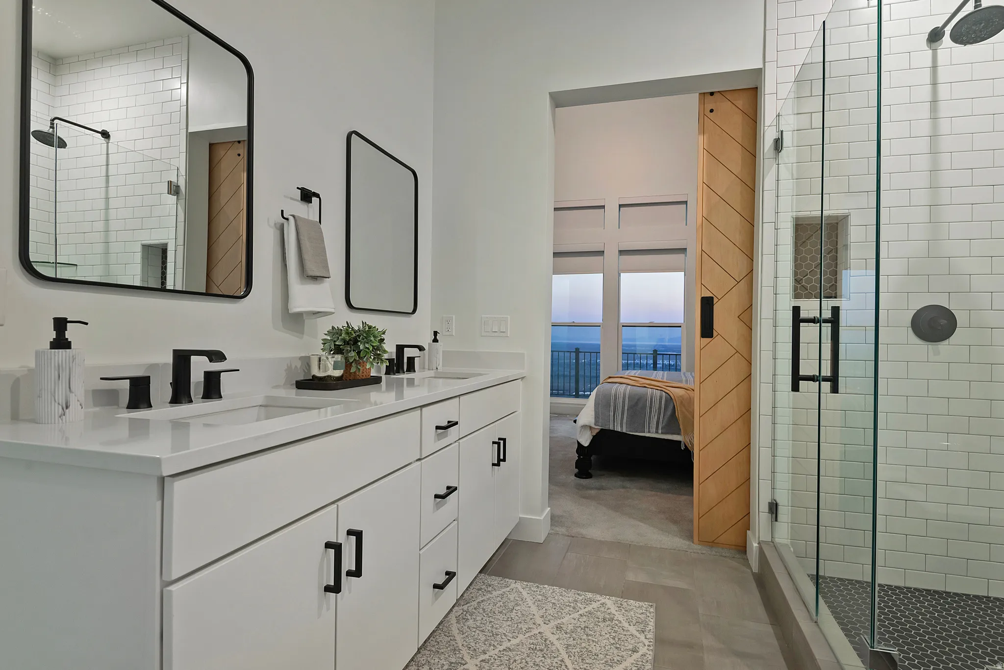 Bathroom with a double vanity featuring white cabinetry, matte black hardware, and integrated sinks