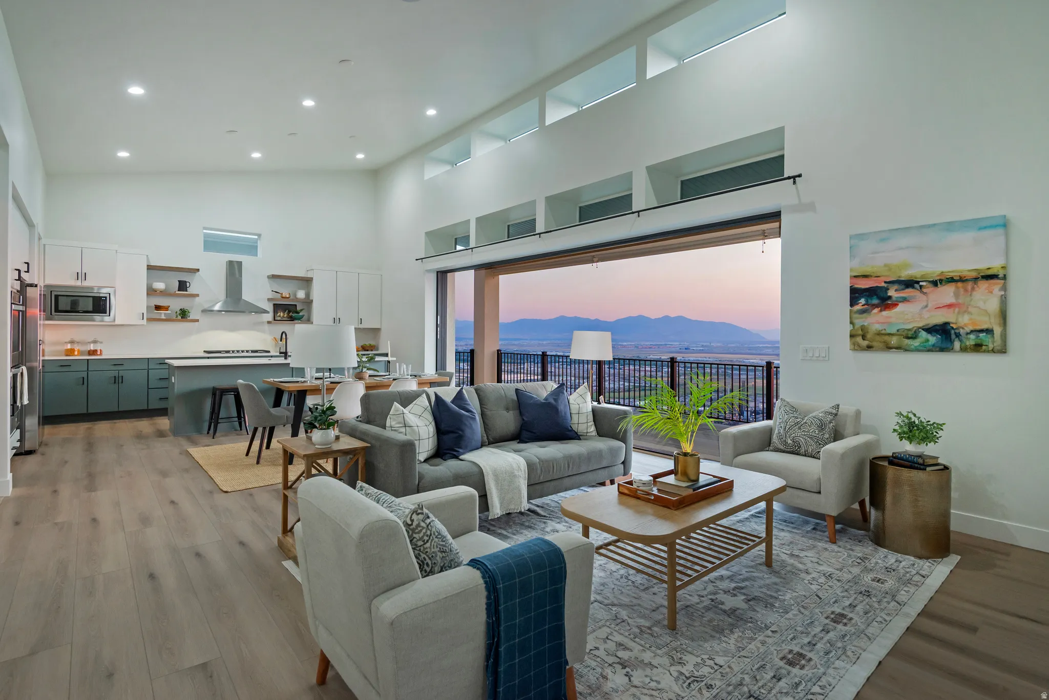 Open-concept living space featuring high ceilings, wood-finish flooring, and ample natural light from clerestory windows