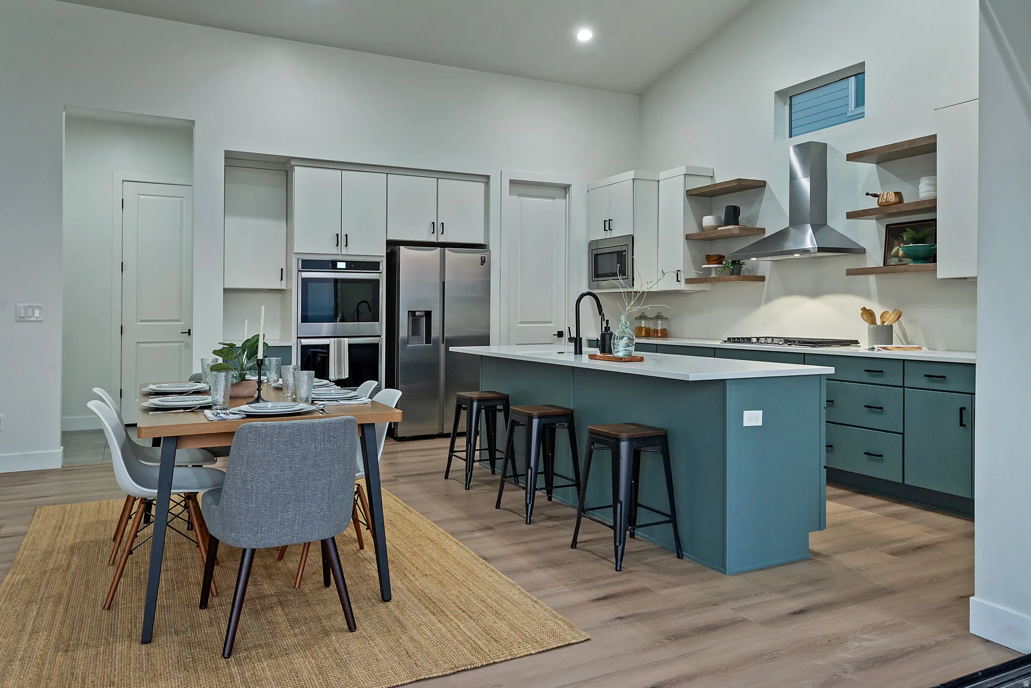 Open-concept kitchen and dining area featuring a vaulted ceiling and wood-finish flooring