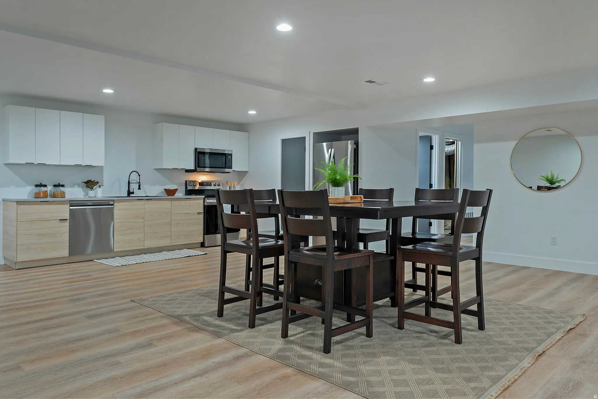 Open-concept kitchen and dining area featuring recessed lighting, a stainless steel dishwasher, and a microwave