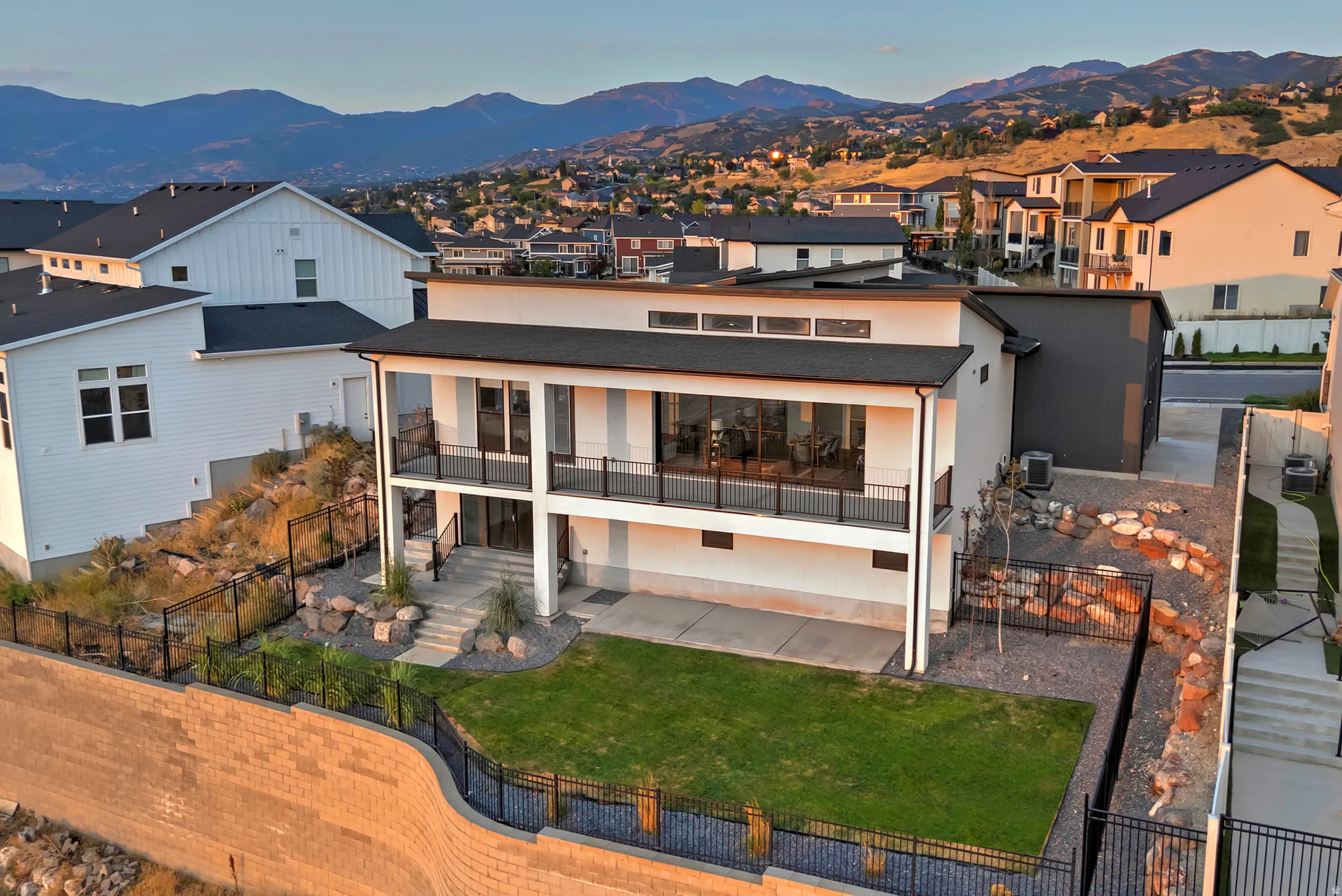 Contemporary two-story residence featuring a ground-level patio and an upper-level balcony