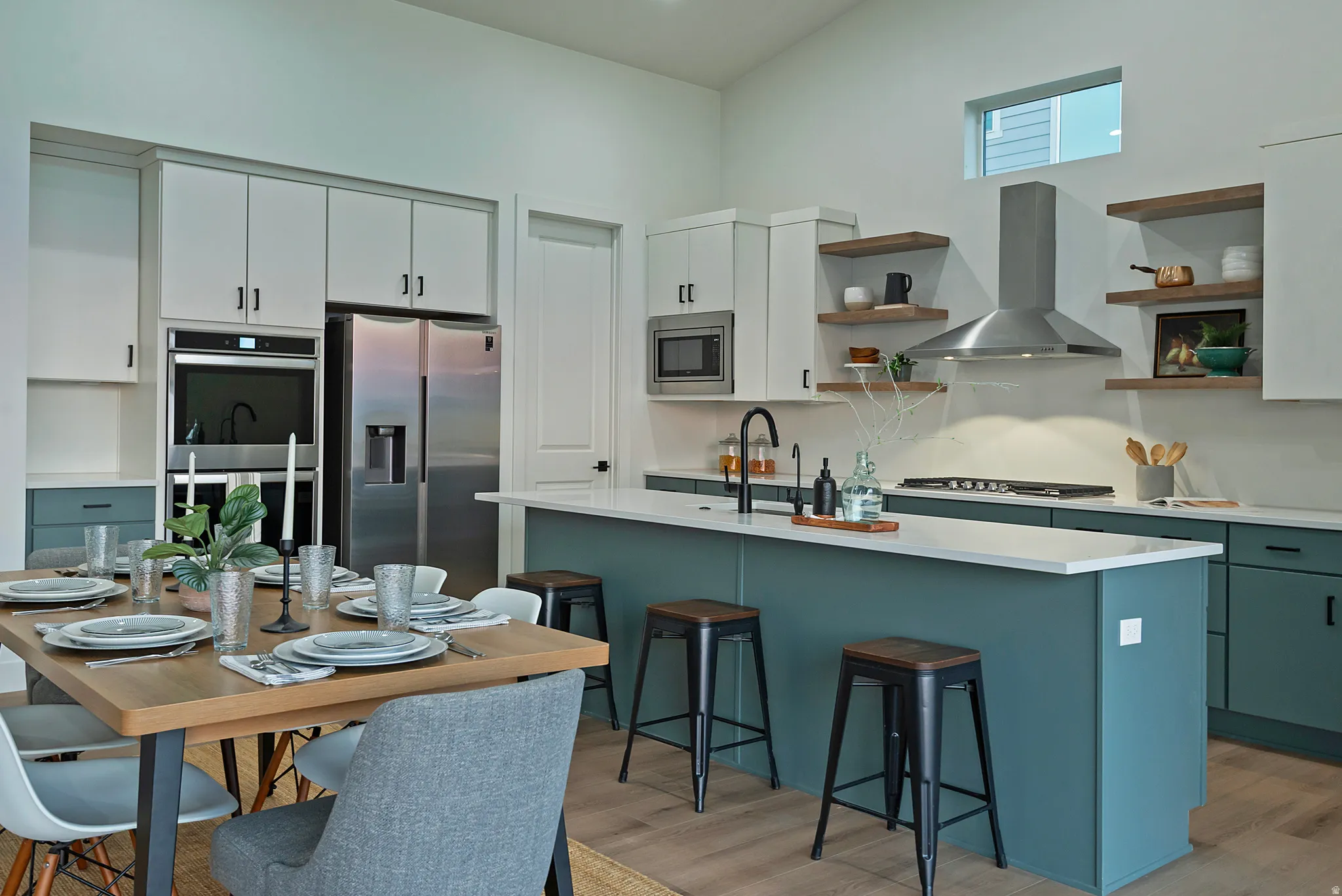 Modern kitchen featuring a two-toned cabinetry design with white upper cabinets and teal lower cabinets