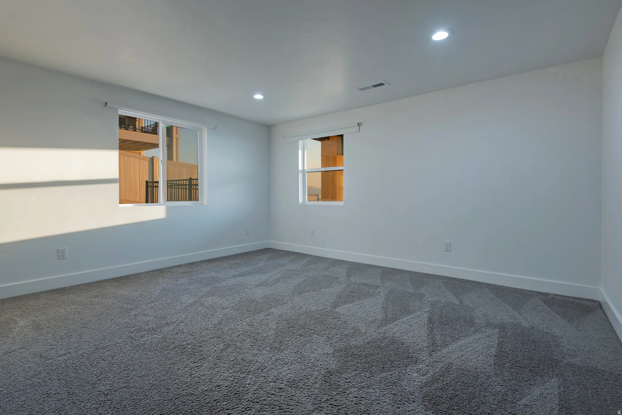 Bright interior room with plush patterned carpeting and clean white walls