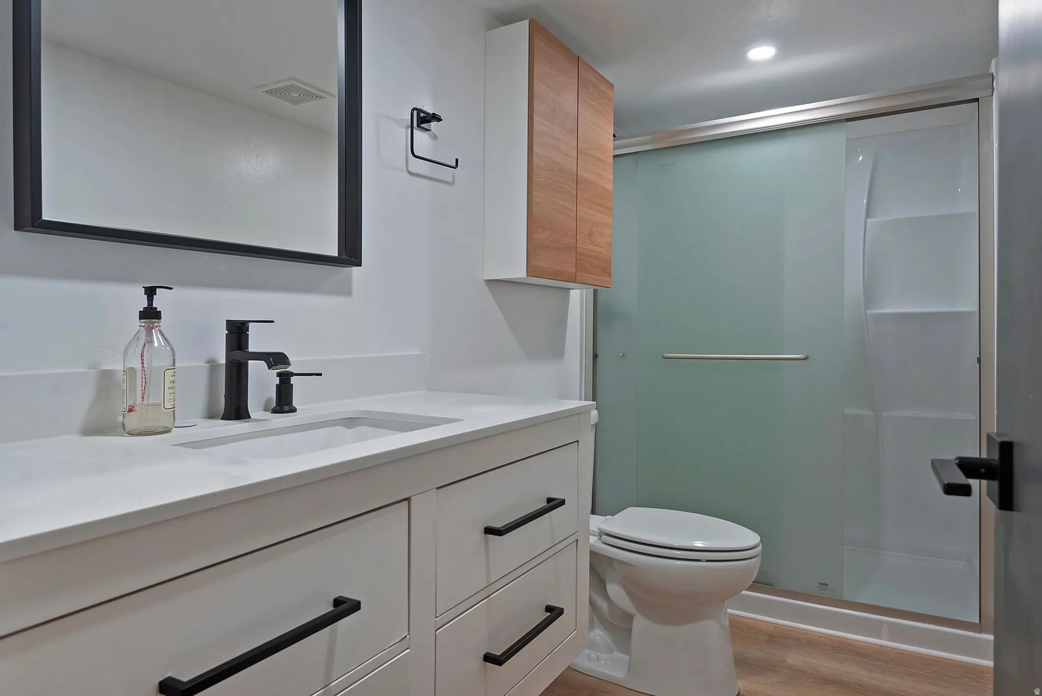 Modern bathroom featuring a single vanity with a white countertop and integrated sink