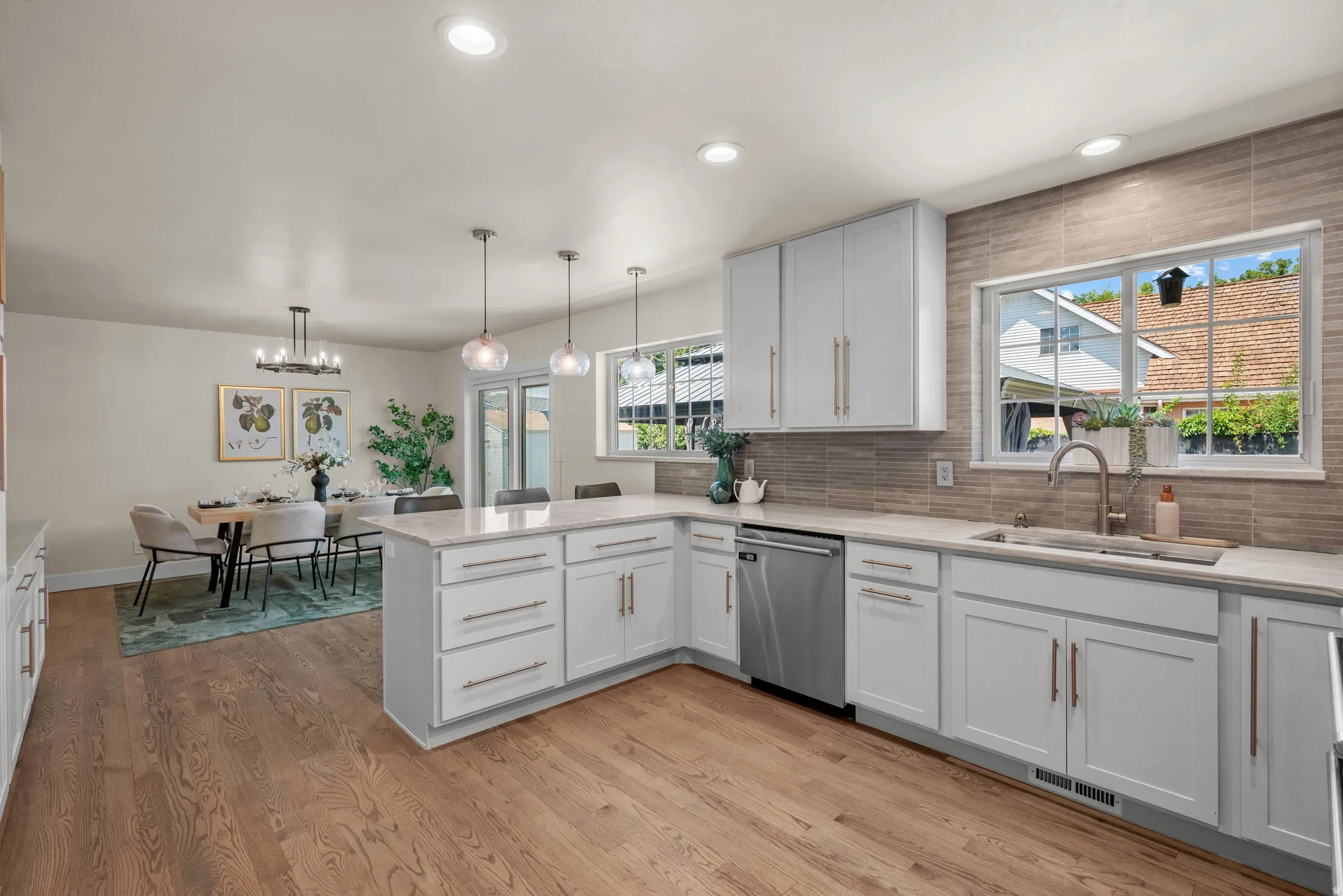 Kitchen featuring white shaker cabinetry, quartz countertops, stainless steel appliances, and wood-finish flooring