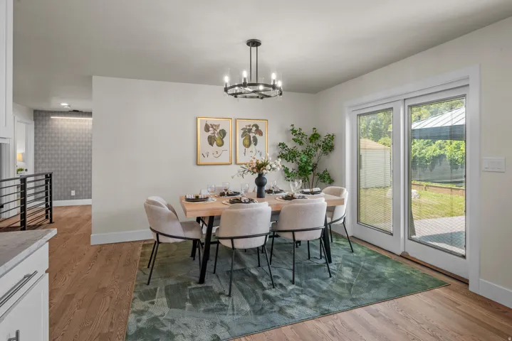 Dining area featuring wood-finish flooring, a contemporary chandelier, and light-toned walls