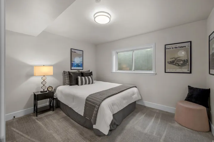 Bedroom featuring light gray wall paint, a single window, and plush carpet flooring