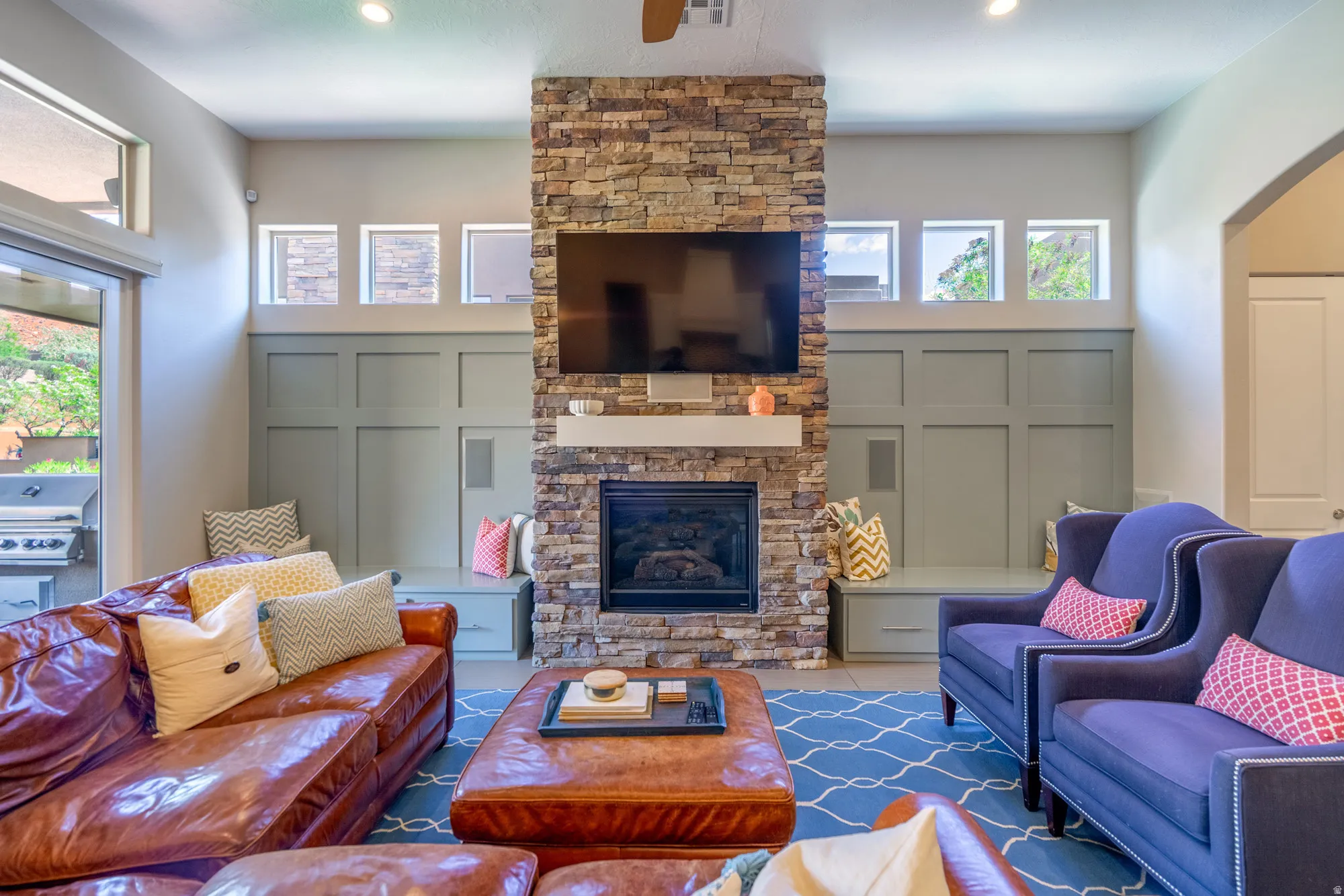 Stacked stone fireplace with a white mantel and recessed hearth