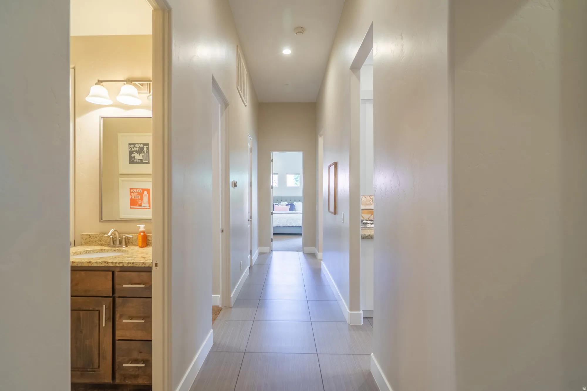 Hallway featuring light neutral walls and tile flooring