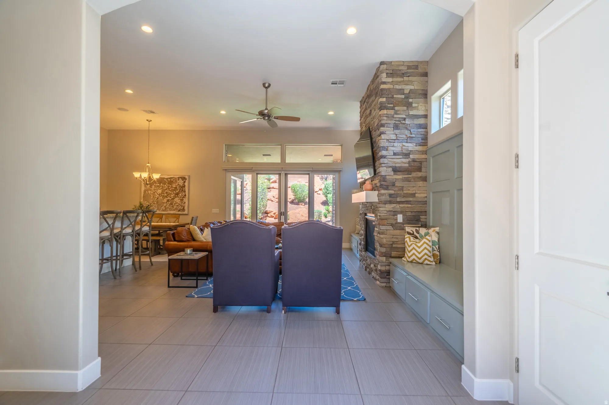 Open concept living area with light-toned tile flooring throughout