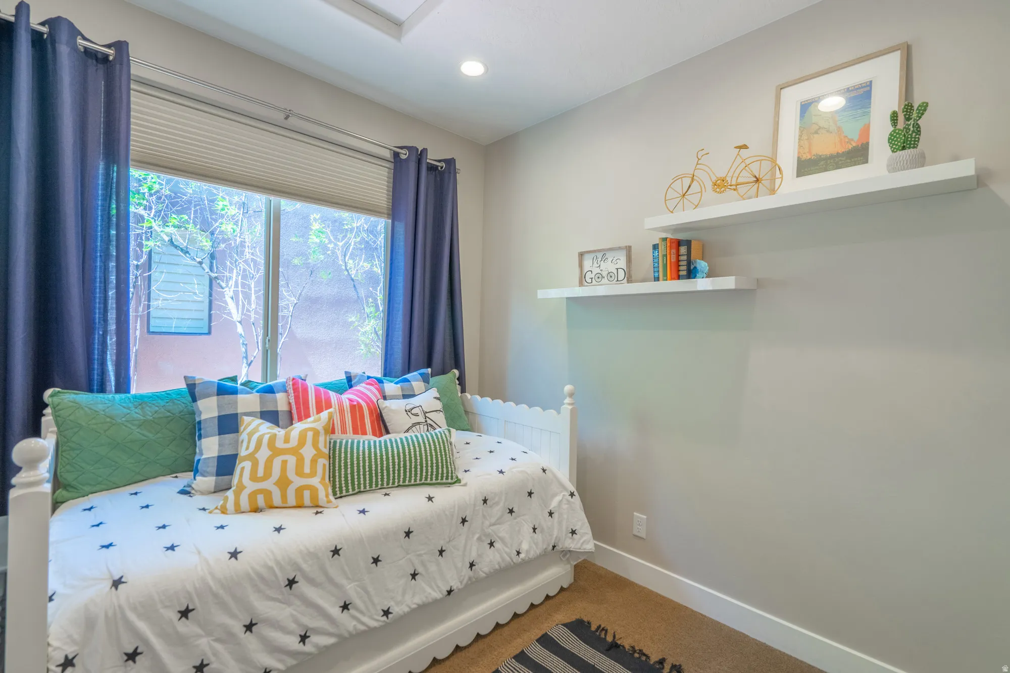 Interior room featuring neutral wall paint, recessed lighting, and a large window with privacy blinds