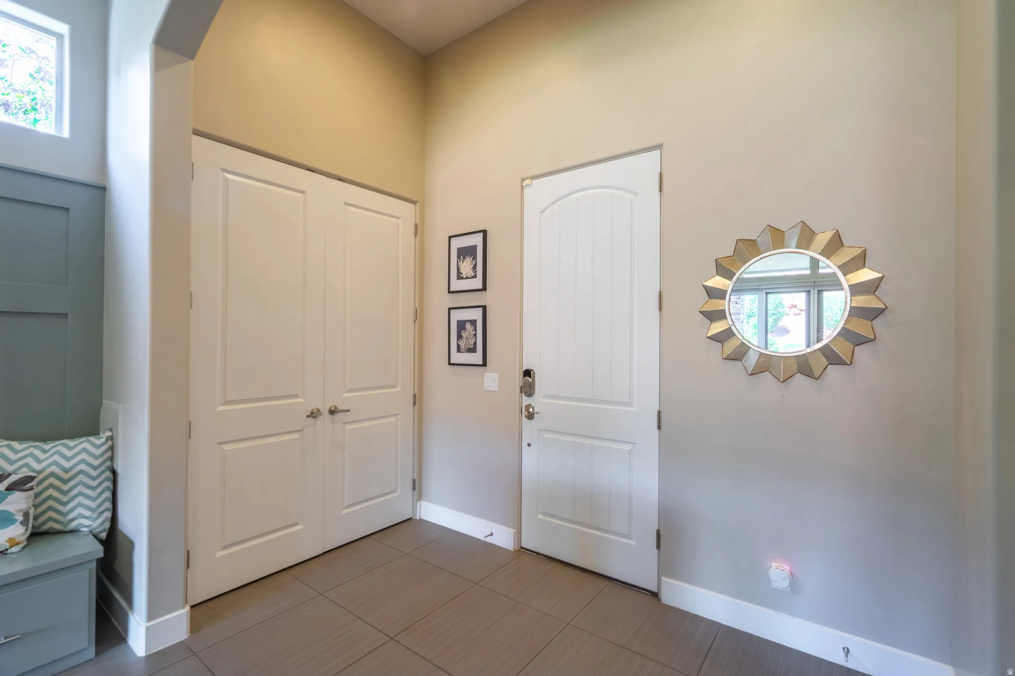Entryway featuring tile flooring, a paneled arch-top door, and a pair of double panel doors