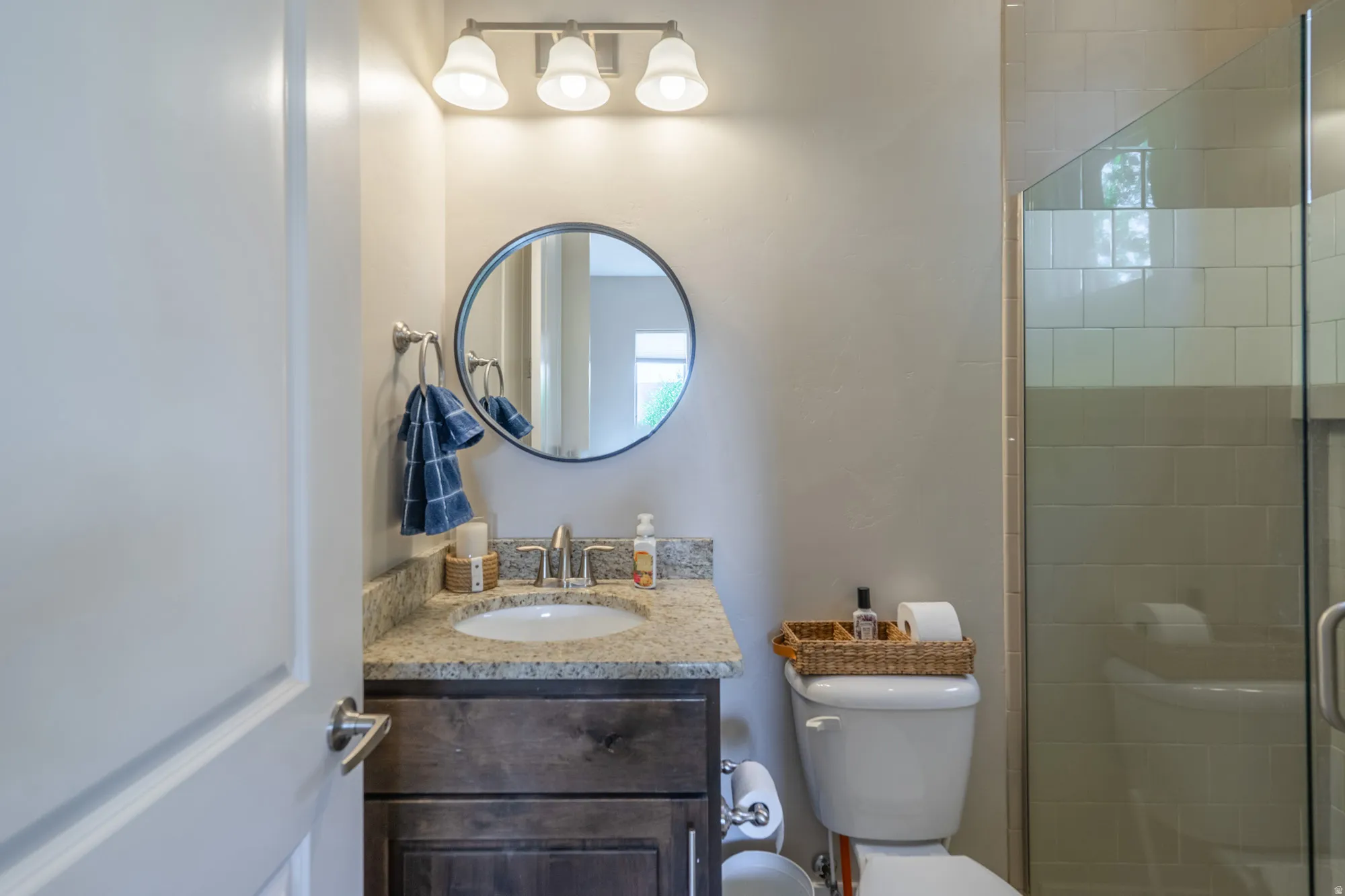 Bathroom featuring a vanity with a granite countertop, undermount sink, and wood-finish cabinetry
