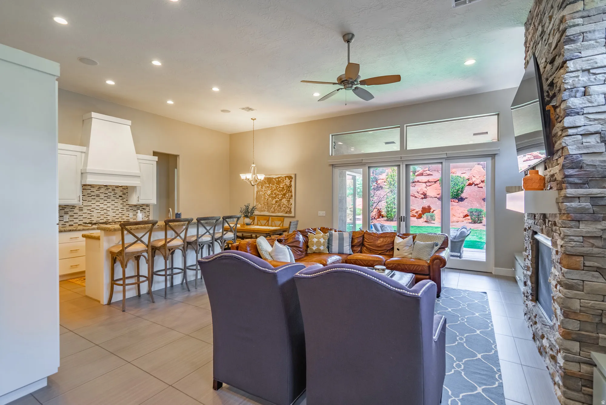 Expansive living area with a stone-clad fireplace and wood-finish flooring
