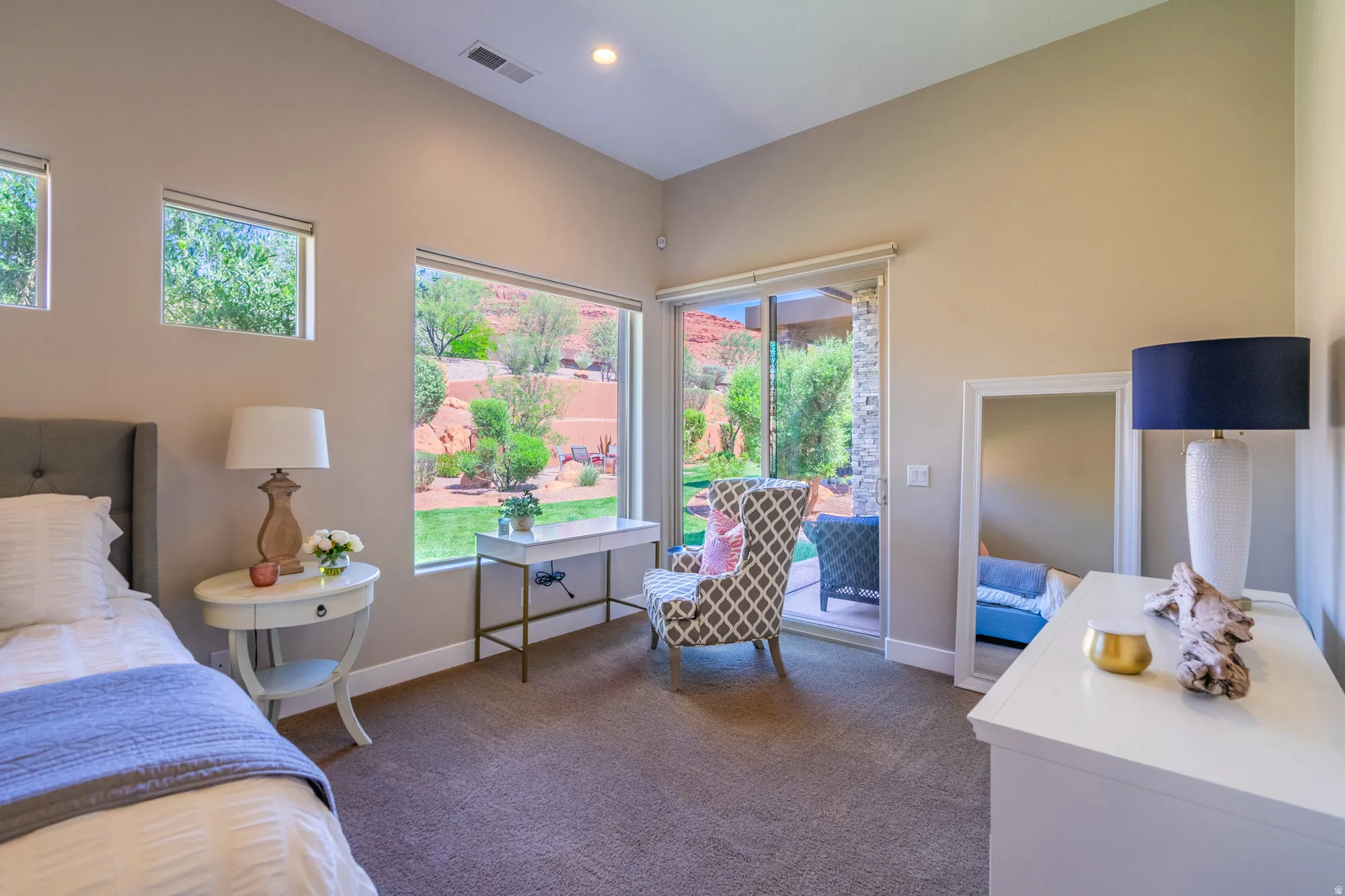 Spacious room with large windows, a sliding glass door, and neutral-toned carpeting