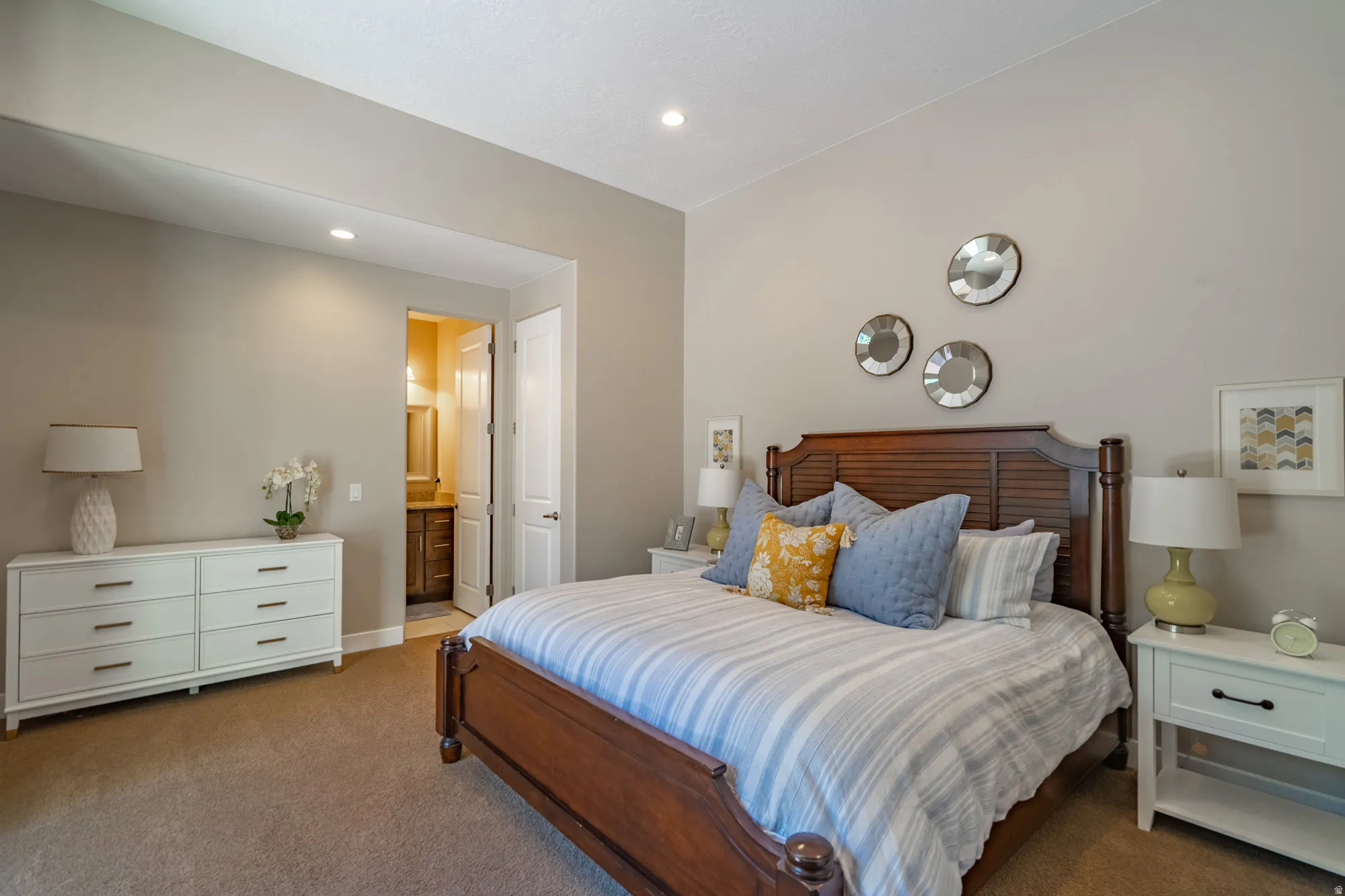 Spacious bedroom with neutral wall tones and recessed lighting