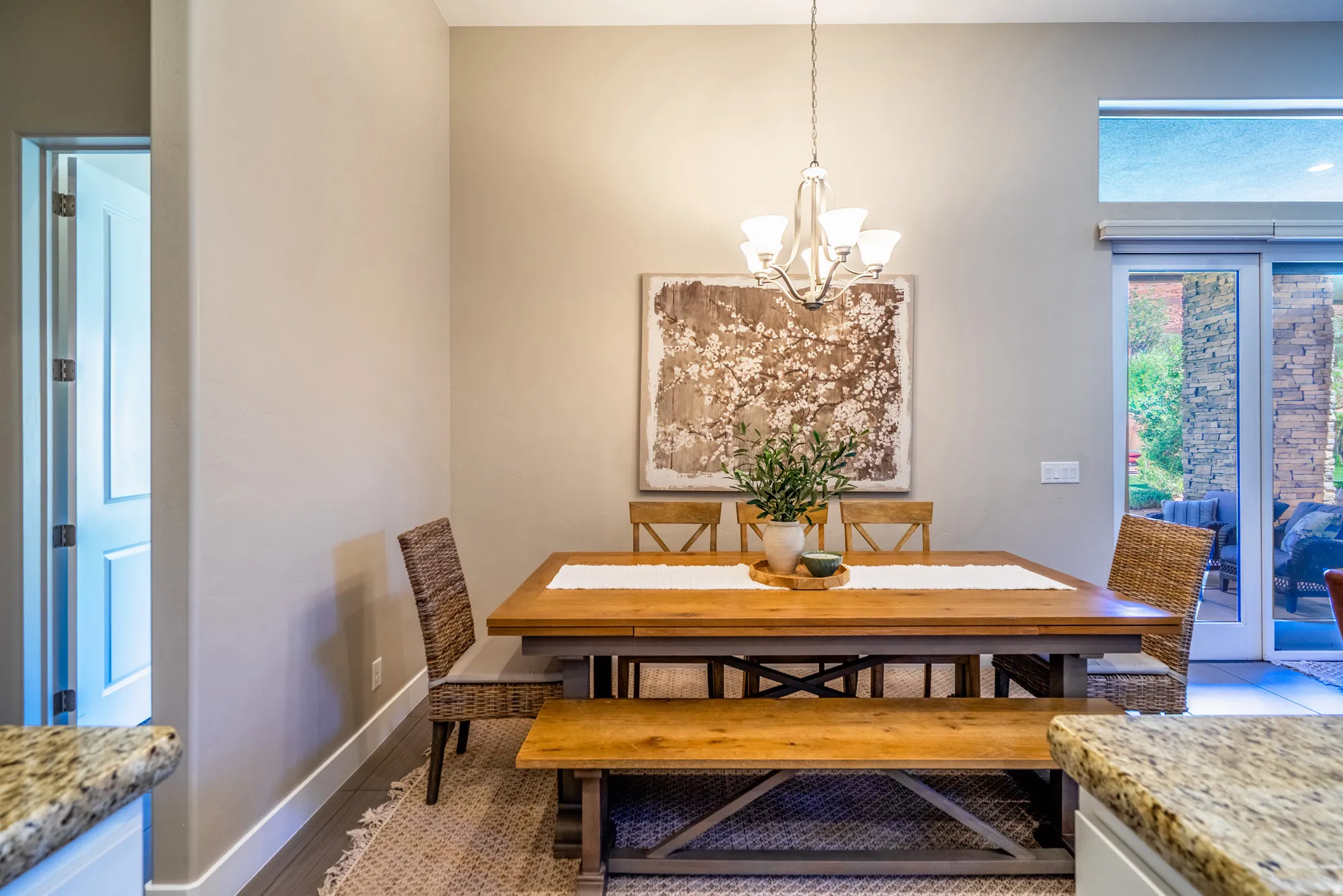 Dining area featuring a wood-finish table, a decorative chandelier, and a wood-finish bench