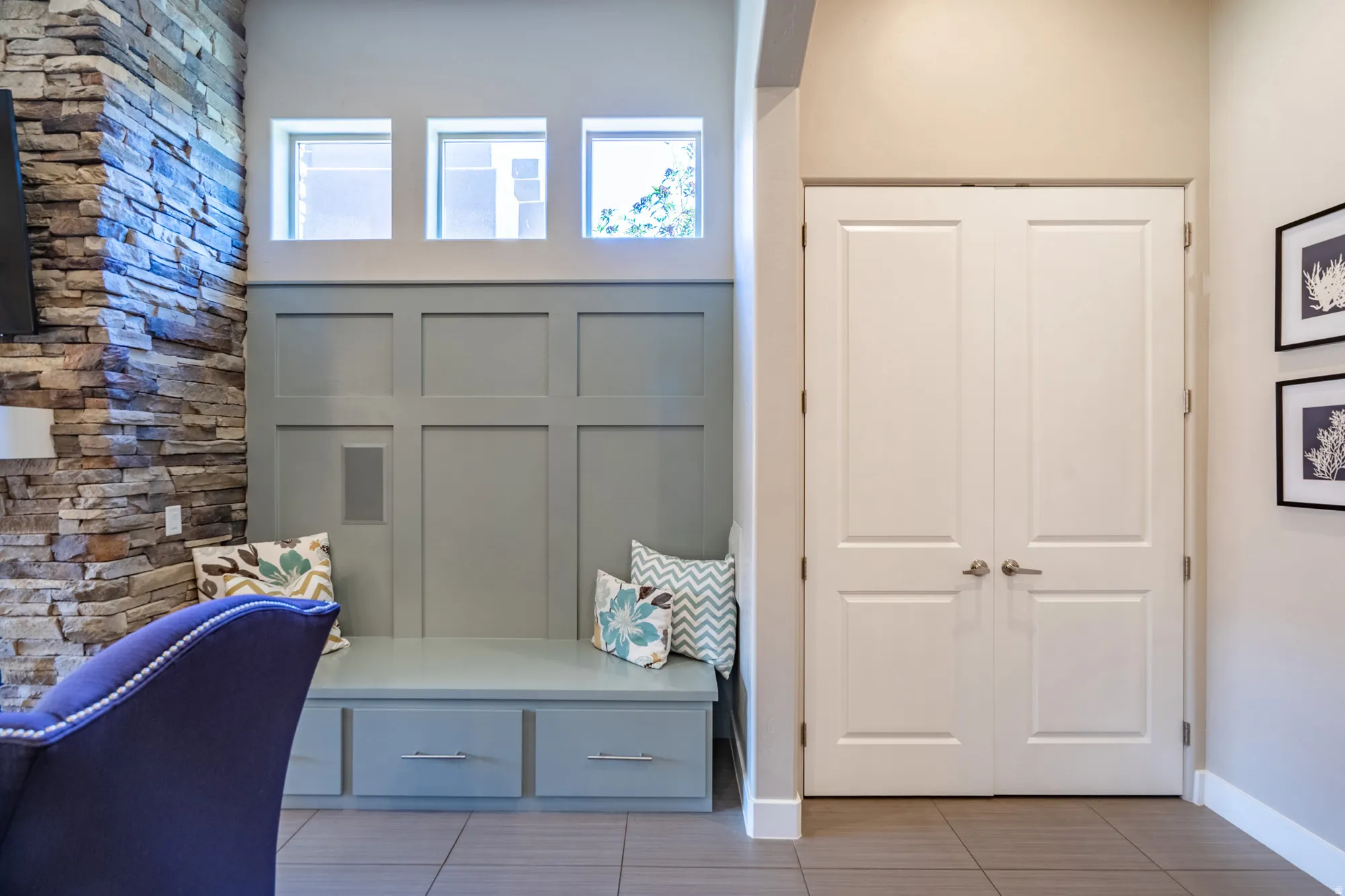 Built-in bench seating with storage drawers, paneled wainscoting, and upper transom windows