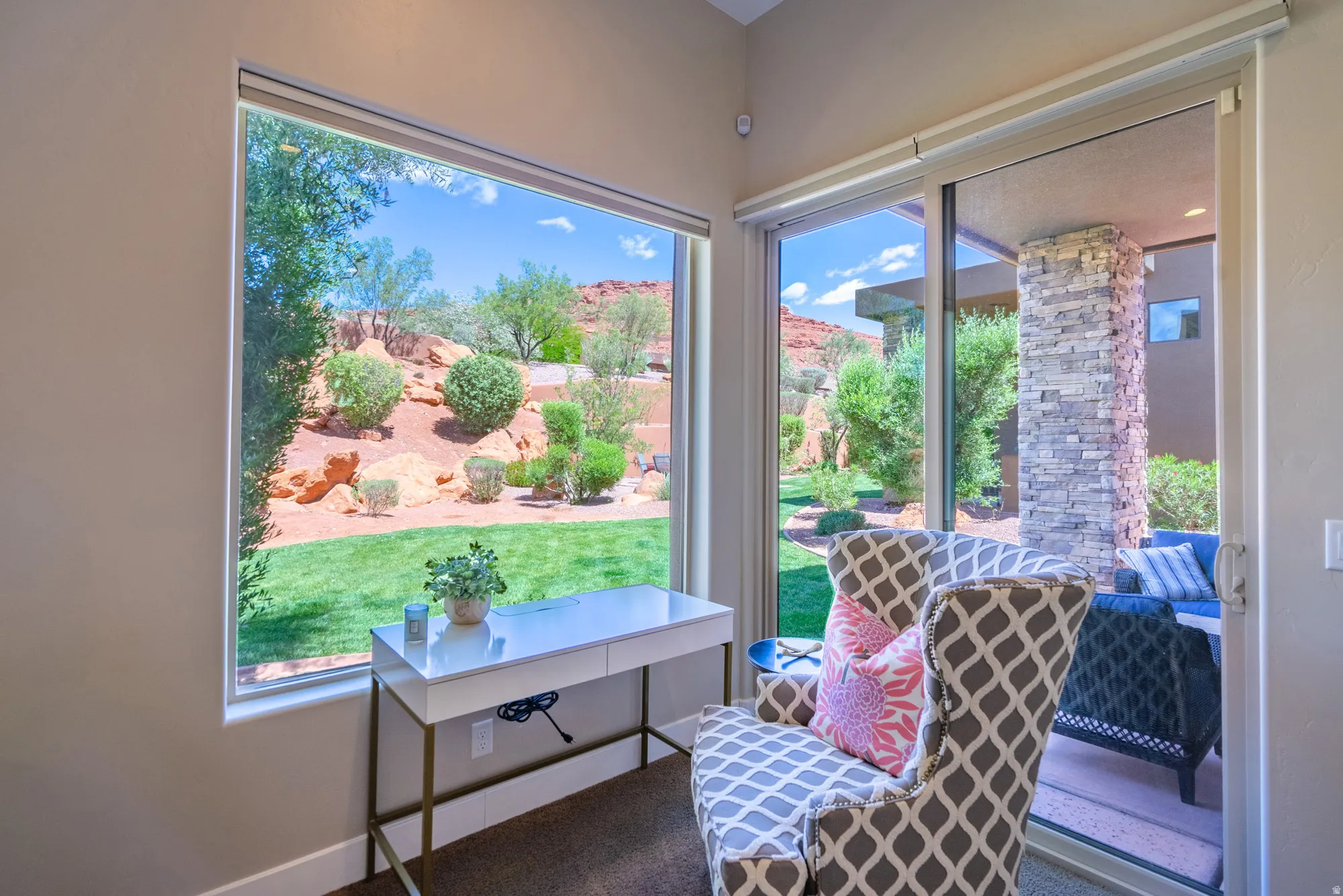 Expansive window offering a broad view of the landscaped yard and distant red rock formations