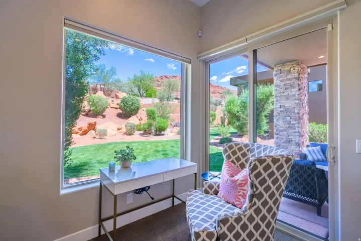 Expansive window offering a broad view of the landscaped yard and distant red rock formations