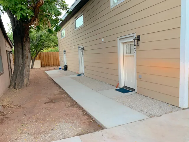 Exterior featuring neutral-toned siding and two white entry doors with integrated window panes