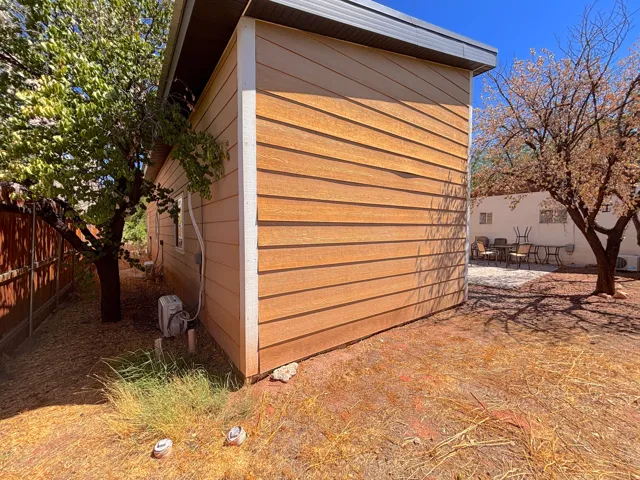 Exterior siding with horizontal wood-finish planks, white trim, and a dark metal roofline