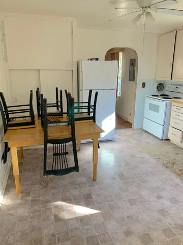 Kitchen area with square tile-pattern flooring and white appliances
