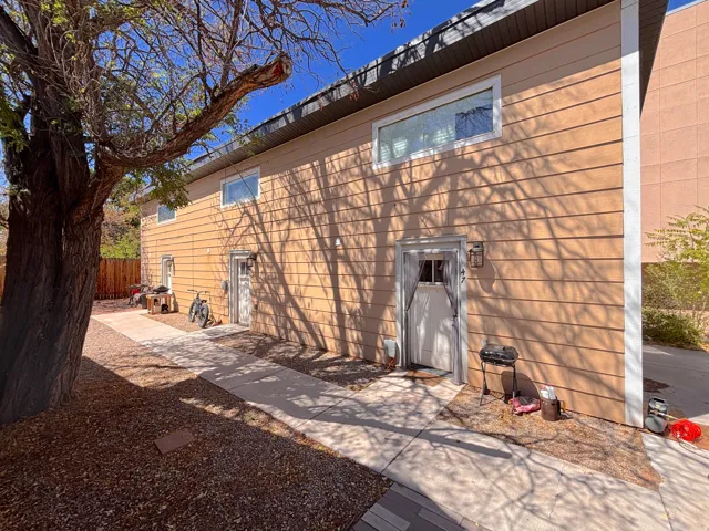 Exterior facade featuring horizontal siding and multiple entryways with individual lighting fixtures