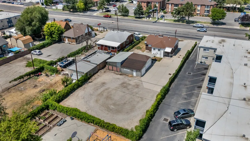 Expansive gravel lot surrounded by established green hedging