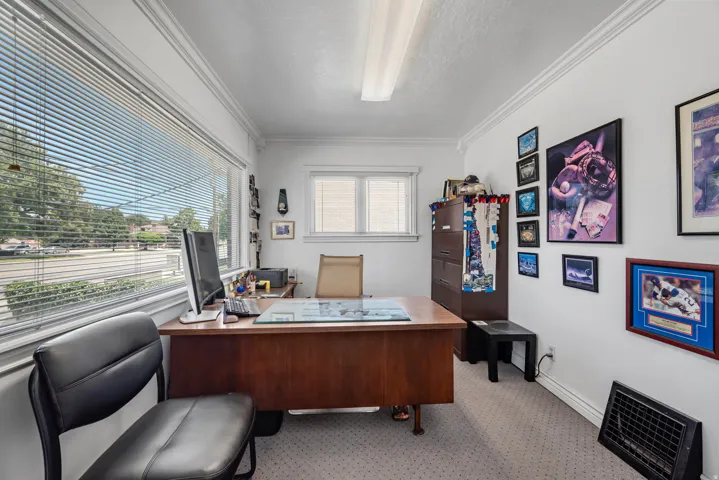 Dedicated office space featuring expansive window with blinds, recessed lighting, and wall-to-wall carpeting
