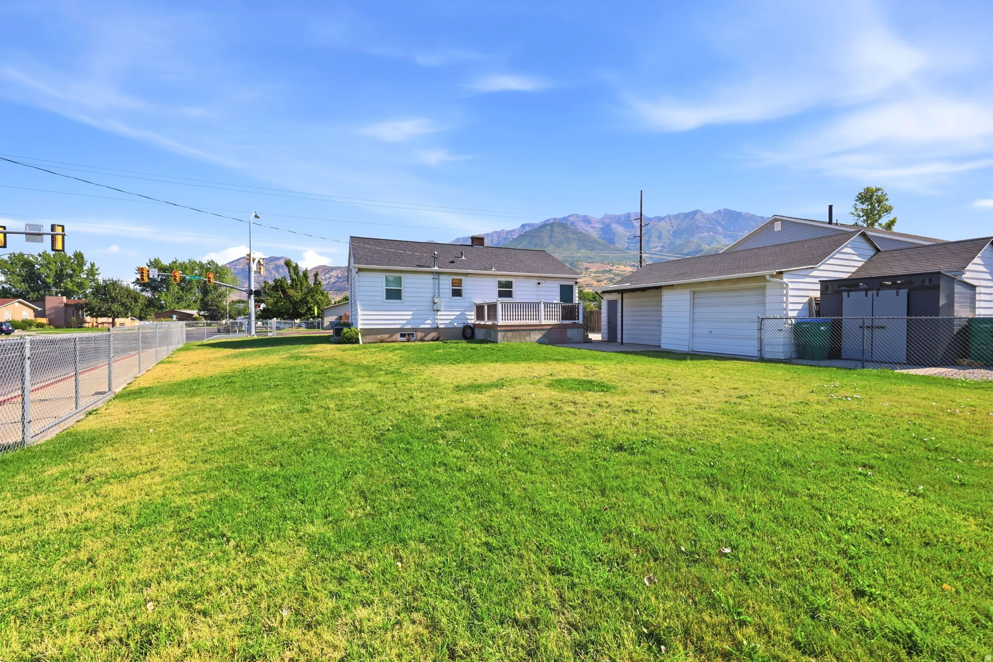 Expansive grassy yard with a chain-link fence