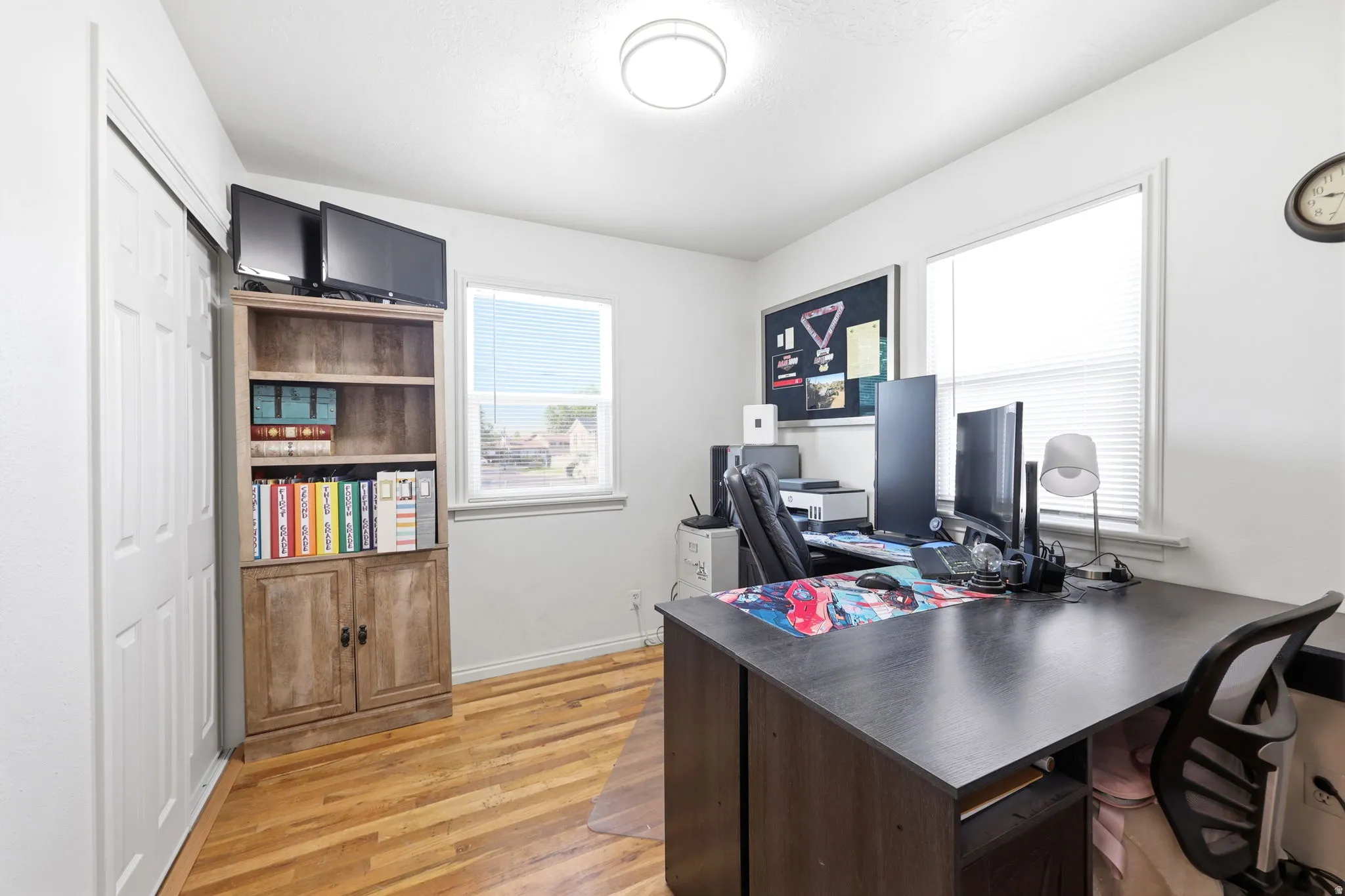 Room featuring wood-finish flooring, white walls, and a ceiling-mounted light fixture