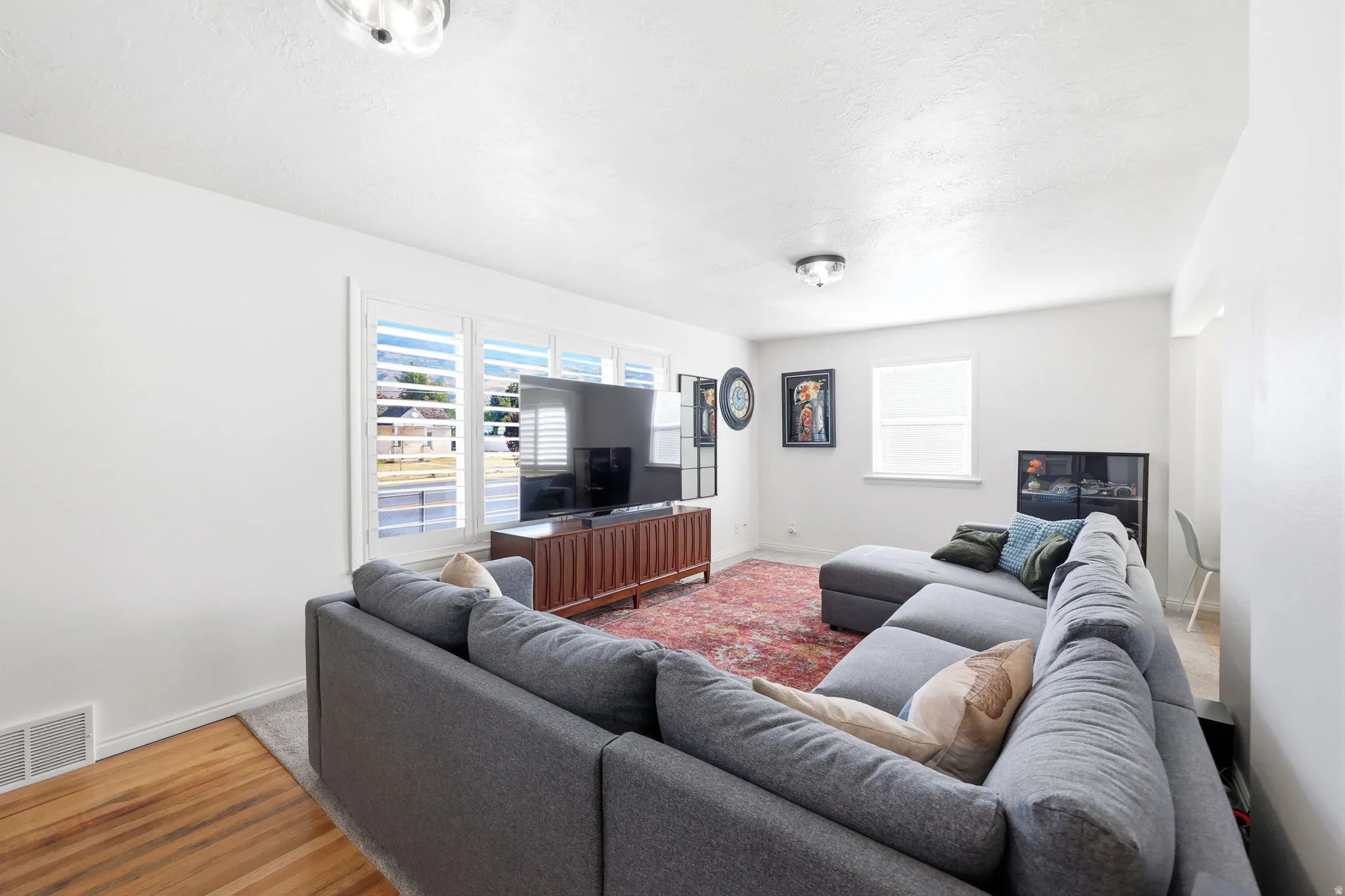 Laminate wood-finish flooring with a white baseboard trim and white walls