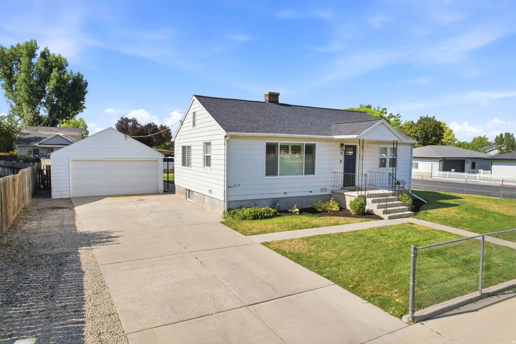 White siding residence with a dark roof and a covered entryway
