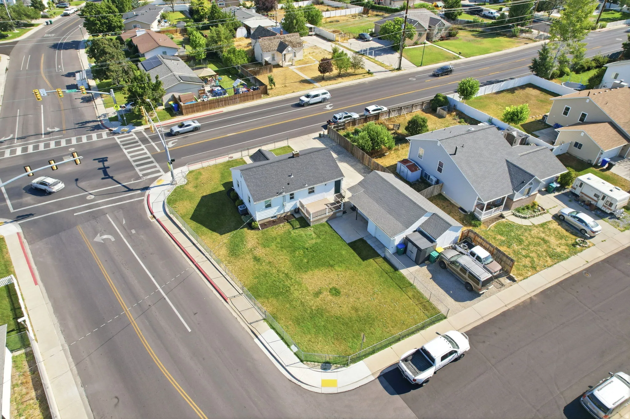 Corner lot with a single-family residence featuring light blue siding and a dark shingle roof