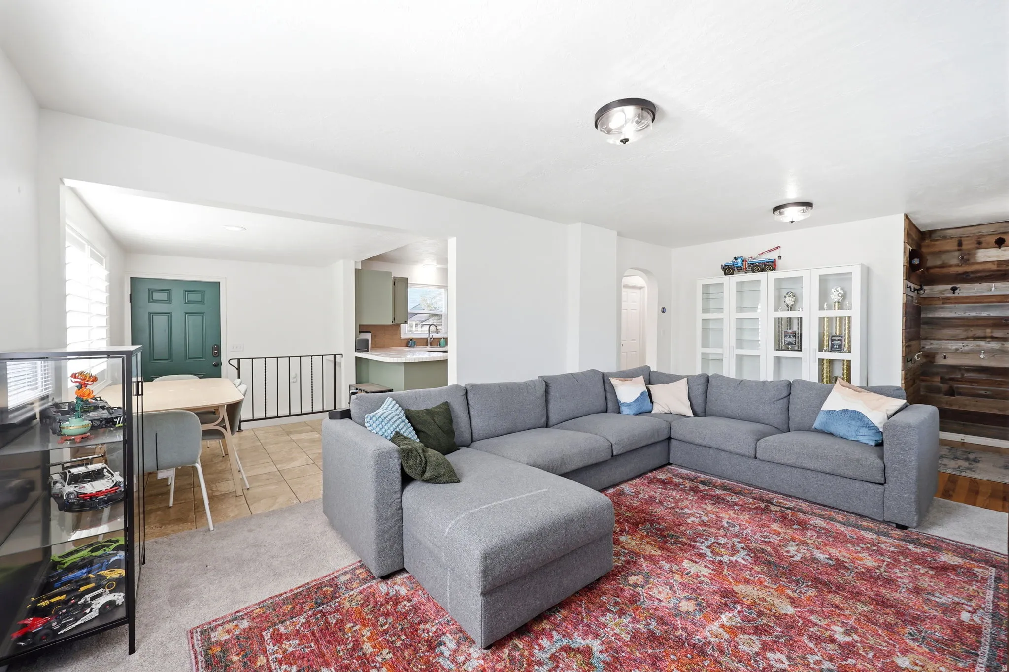 Open-concept living area featuring light neutral walls and carpeted flooring