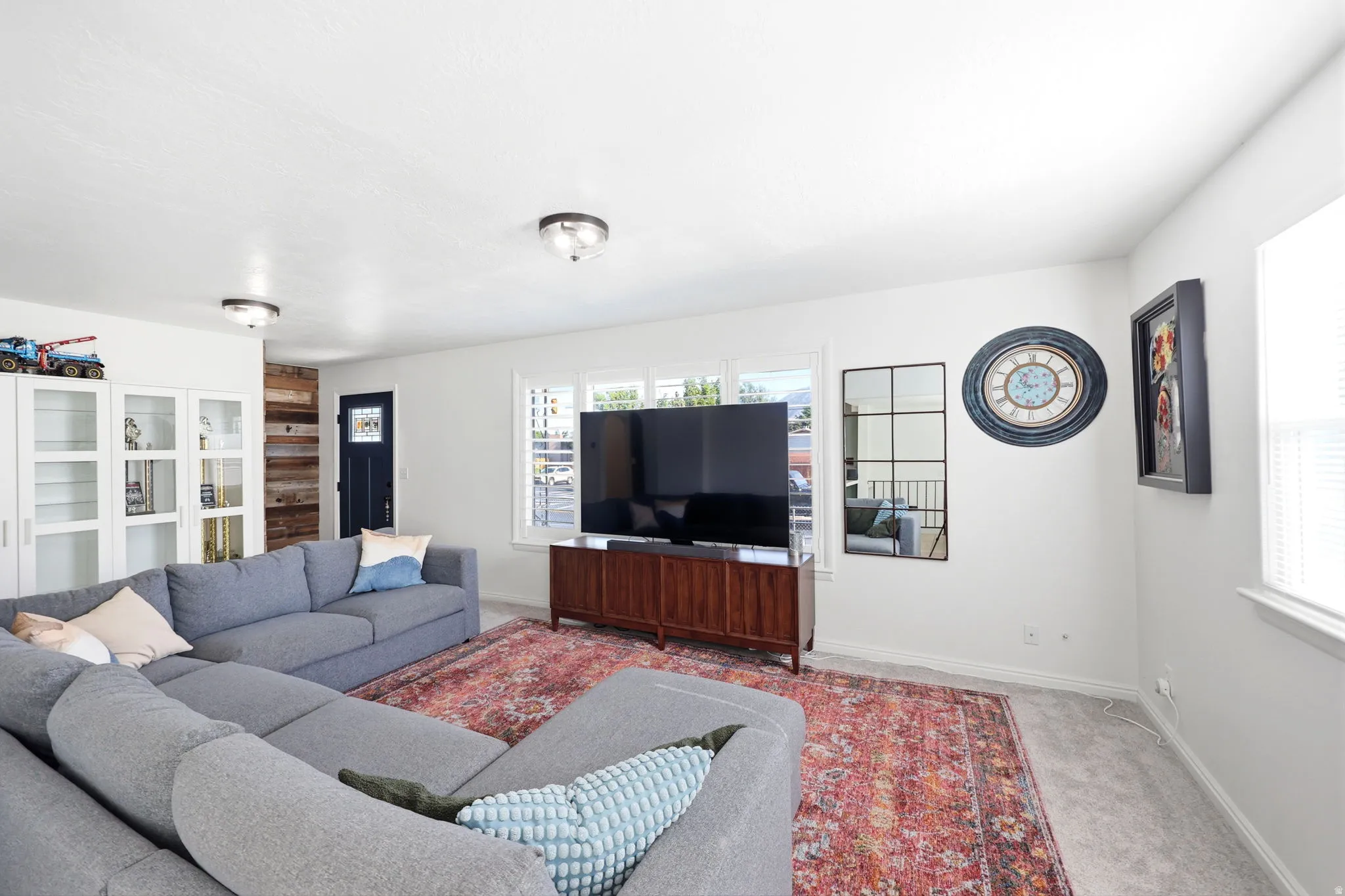 Bright living area with white walls and light gray carpeting