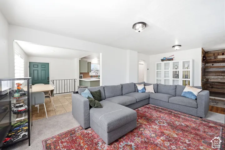 Open-concept living area featuring light neutral walls and carpeted flooring