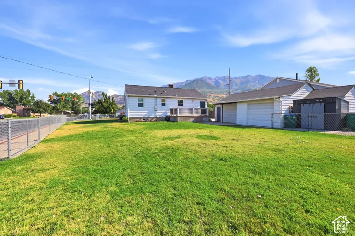 Expansive grassy yard with a chain-link fence