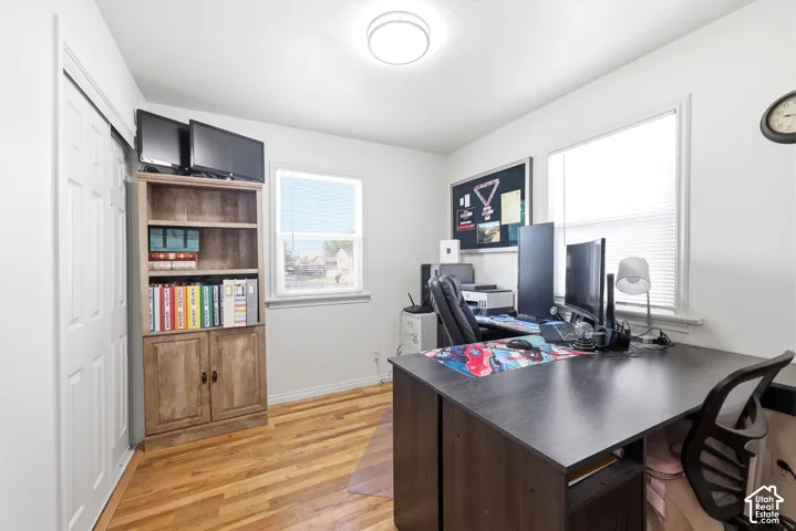 Room featuring wood-finish flooring, white walls, and a ceiling-mounted light fixture