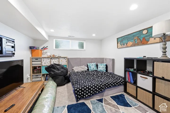 Carpeted room with recessed lighting and a window offering natural light