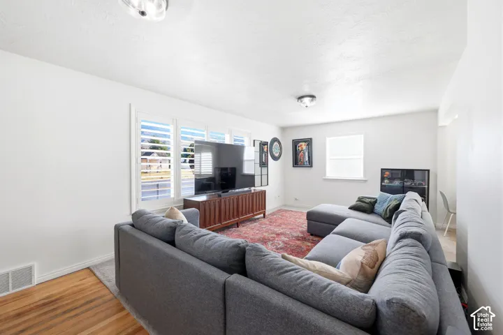 Laminate wood-finish flooring with a white baseboard trim and white walls