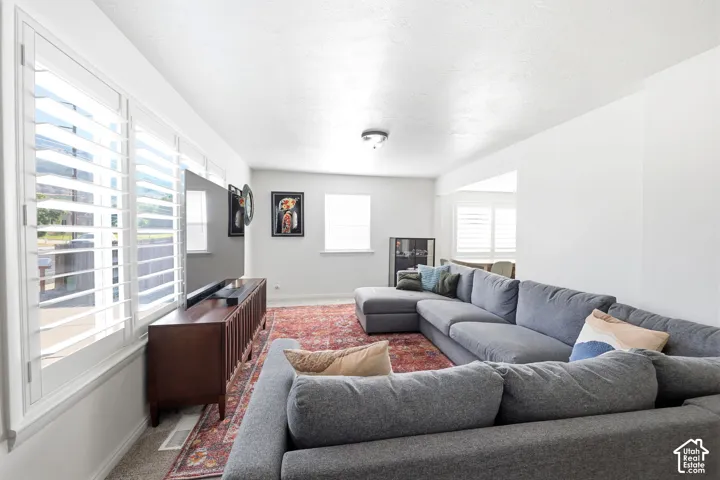 Bright living space featuring white walls and white plantation shutters on multiple windows