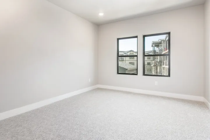 Neutral-toned room with light gray carpet flooring and white baseboards