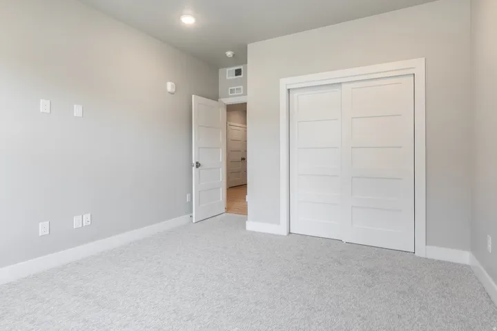 Room featuring light gray wall paint, white baseboards, and light gray textured carpeting