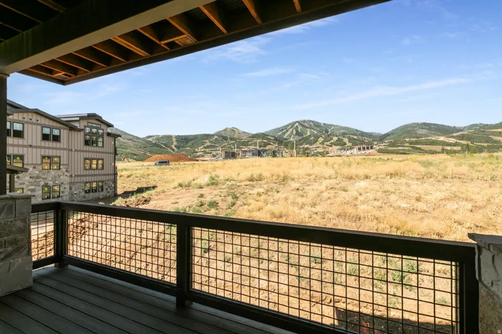 Covered outdoor deck with composite decking and metal grid railing