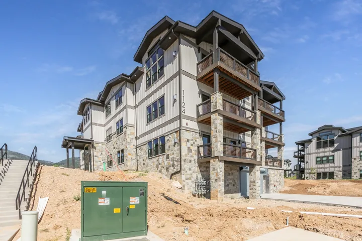Multi-story building featuring natural stone veneer and vertical siding accents